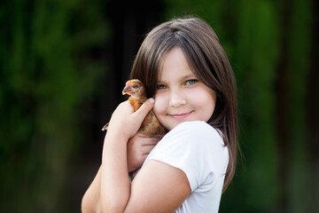 Fototapeta dzieci i zwierzęta - dziewczynka przytula z miłością swoją kurkę obraz