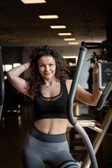 Fototapeta na wymiar Hot steamy gym session with curly brunette toned female model