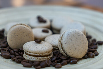 Selective focus on coffee beans and french macarons in a serving plate, macaroons and coffee beans