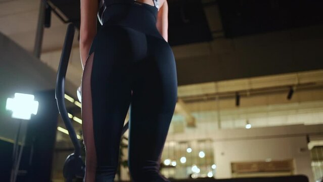 female running on elliptical orbitrek machine in fitness gym or apartment