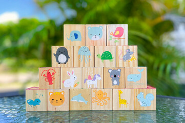 wooden game cubes for kids palm tree in the background. symbols on cubes