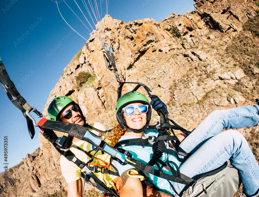 Wall mural happy tourist doing paragliding sport activity in outdoor leisure active lifestyle. cheerful adult w