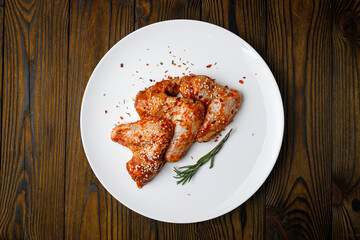 meat products on a white plate on a wooden table
