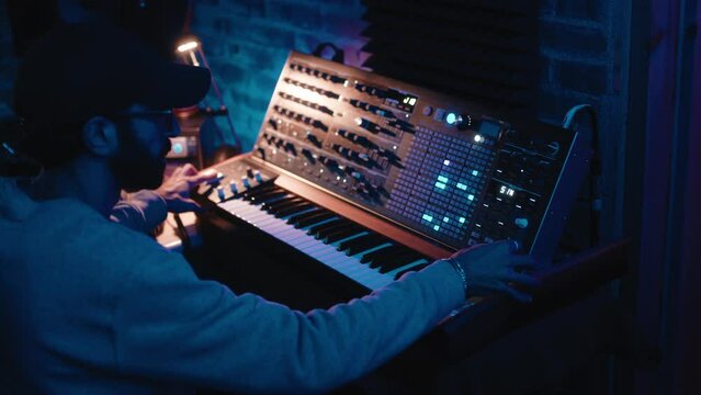 Music producer working on synthesizer