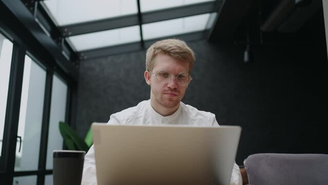 freelancer architect is working in coworking space or cafe in daytime, using laptop with architectural program