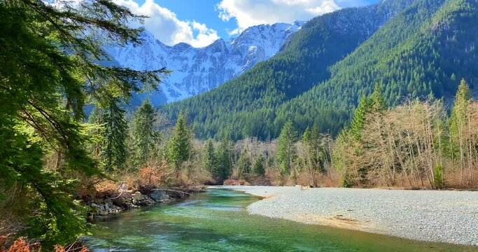 Establishing shot of majestic mountain river with mountain background in Vancouver, Canada, North America. Day time on April 2021. Still camera view. ProRes 422 HQ.