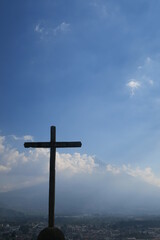 The amzing view from the mirador with the holy cross in front and the Acatenango volcano in the background from the city of Antigua in Guatemala in Central America on a sunny day