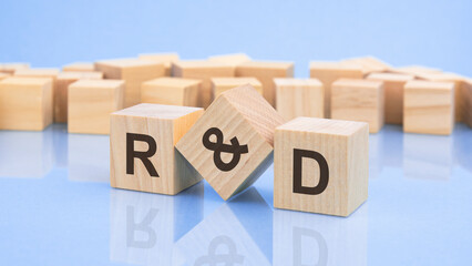 three wooden cubes with the letters r and a on the bright surface of a pale lilac table. the inscription on the cubes is reflected from the surface of the table. business concept