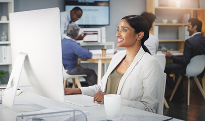 Positivity improves productivity. Shot of a young businesswoman using a computer at her work desk.