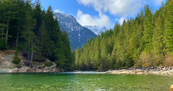 Establishing shot of majestic mountain river with mountain background in Vancouver, Canada, North America. Day time on April 2021. Still camera view. ProRes 422 HQ.