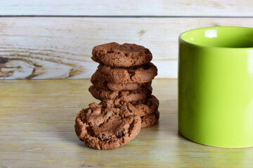 Cup of tea and stacked chocolate chip cookies.