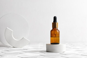 Glass brown bottle with natural essential oils, Hyaluronic acid on a white podium on tile background