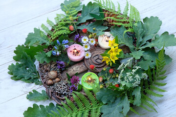 Wiccan Altar for Summer solstice, Litha pagan holiday. wheel of the year with oak, fern leaves, flowers, pentagram, candles on wooden table. symbol of celtic wiccan sabbath, summer season. - obrazy, fototapety, plakaty