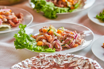 Traditionally made Mexican ceviche. Fish strips with tomato, lettuce, onion, avocado, orange.