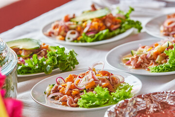 Traditionally made Mexican ceviche. Fish strips with tomato, lettuce, onion, avocado, orange.