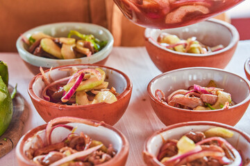 Traditionally made Mexican ceviche. Fish strips with tomato, lettuce, onion, avocado, orange.