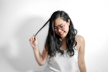 Obraz premium Happy glasses Asian girl touches her hair and smile in white background.