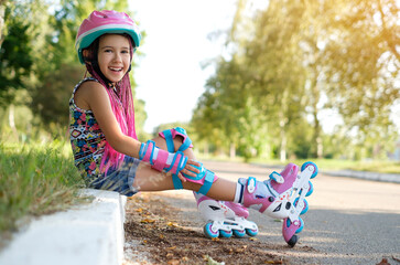 Laughing loudly, a funny girl with Afro-pigtails and wearing sports protective gloves and a helmet...