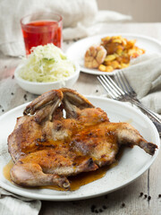 Whole roasted chicken on a plate. Photo of food on a dark background