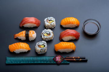 varied sushi ration with black background and props