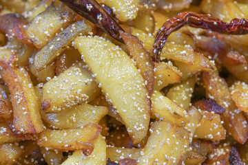 Close up image of fried potato pieces with fried red chilly - a fast food dish . Popular amongst Indians as a tasty snacks.