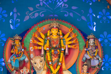 Goddess Durga idol at decorated Durga Puja pandal, shot at colored light, at Kolkata, West Bengal,...