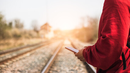 young photographer walking along train track