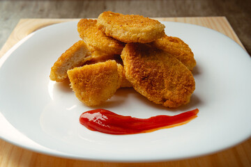 Chicken nuggets with crispy fried bread, wooden bottom. Tasty chicken nuggets.