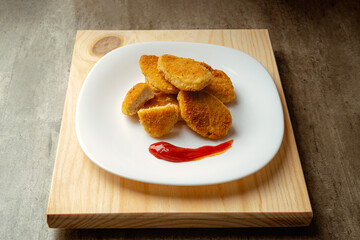 Chicken nuggets with crispy fried bread, wooden bottom. Tasty chicken nuggets.