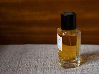 Closeup of luxurious parfume bottle on vintage sofa with space for text