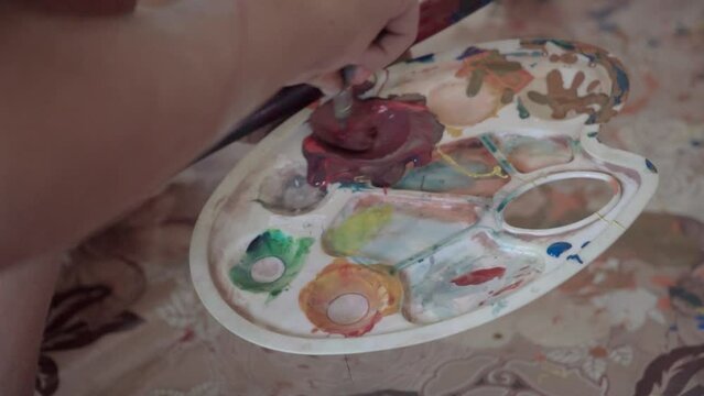 Little child artist sets paints on the palette.close up hd
