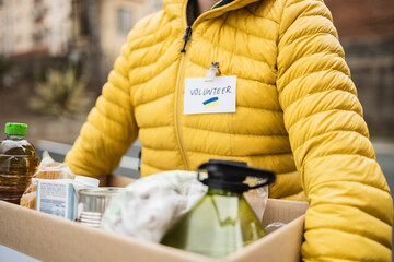 Volunteer collecting box with donations for Ukrainian refugees - Humanitarian aid for Ukraine -...