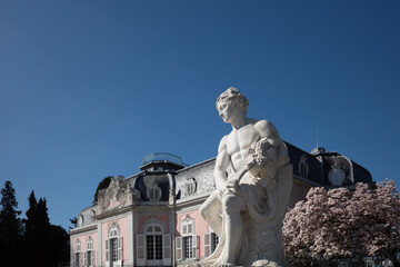 Obraz premium Selective focus at white classical male human sculpture and background of Schloss Benrath, old classic residence palace.