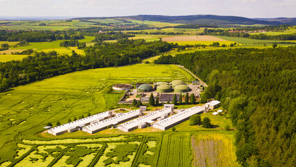 Aerial view of biogas plant near farm in countryside. Ecological renewable energy production from agricultural waste. New green modern agriculture in Dobrany, Czech Republic, European Union. 