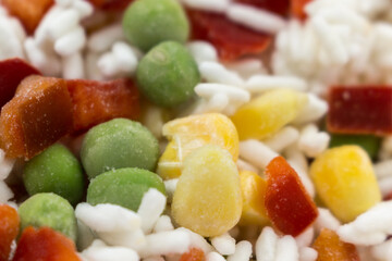 Frozen mixture of rice and vegetables, food background, close-up