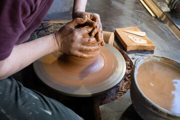 Hands of a potter at work. Potter making ceramic mug on the pottery wheel