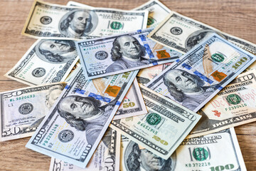Paper, cash American dollar bills on a brown wooden table. The concept of the world economy in the form of a background