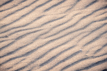 Fototapeta premium Top view of textured background with sand and smooth waves