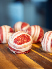 Meatballs filled with cheddar cheese and wrapped with bacon known as moinkballs