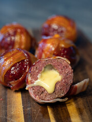 Meatballs filled with cheddar cheese and wrapped with bacon known as moinkballs
