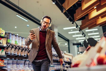 Young man with earphones on enjoying shopping