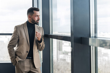 Handsome businessman looking out the window in the office