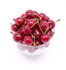 Ripe fresh cherry in the glass isolated on white background