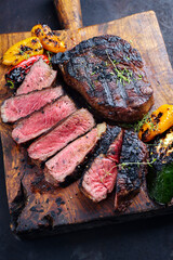 Traditional barbecue dry aged wagyu rib-eye beef steaks served with paprika and zucchini as...