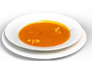 Tomato soup with shrimp and seafood in a plate on a white background.