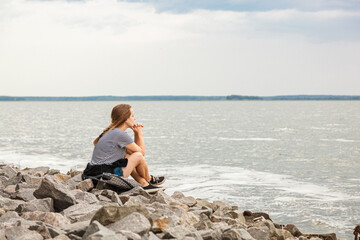 Beautiful girl on the sea with blue sky and clouds