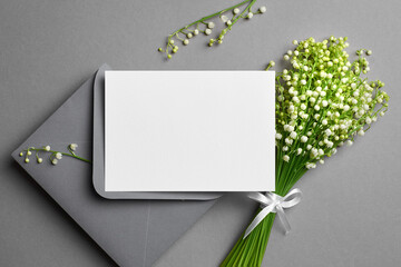 Wedding invitation card mockup with envelope and white lily of the valley flowers