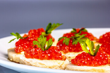 Canapes with salmon caviar and parsley