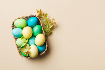 Fototapeta na wymiar Multi colors Easter eggs in the woven basket on colored background . Pastel color Easter eggs. holiday concept with copy space