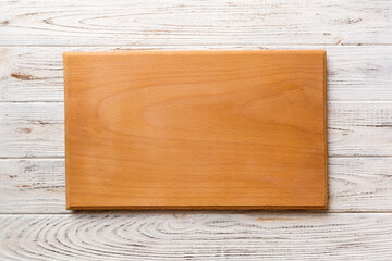 Top view of wooden cutting board on wooden background. Empty space for your design.=